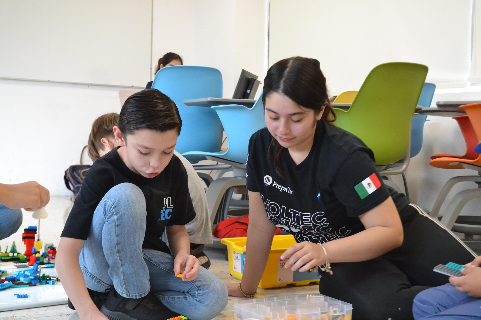 Mentora de Voltec guiando a un alumno en la construcción con LEGO