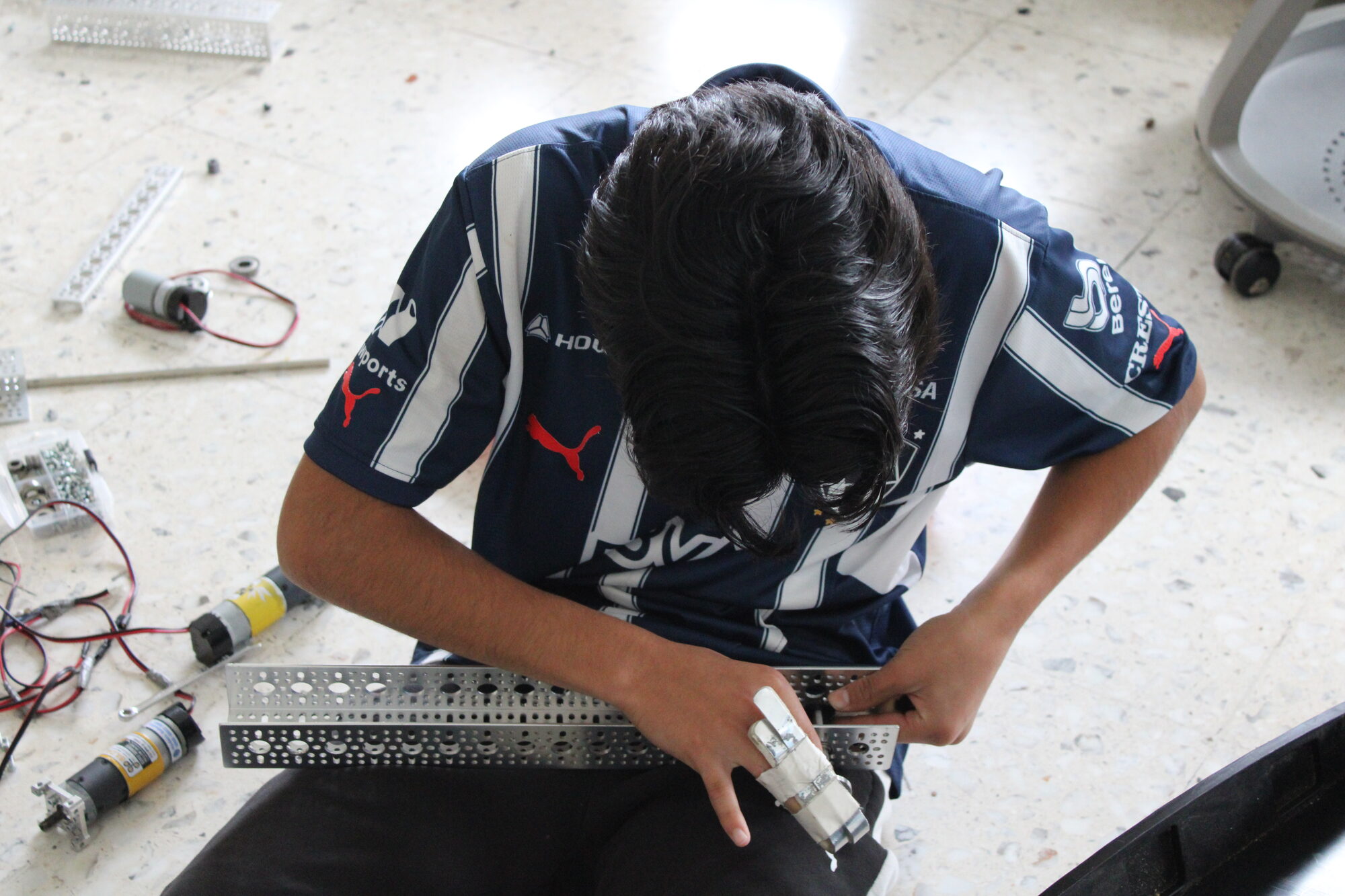 Estudiante manufacturando piezas de un robot FTC