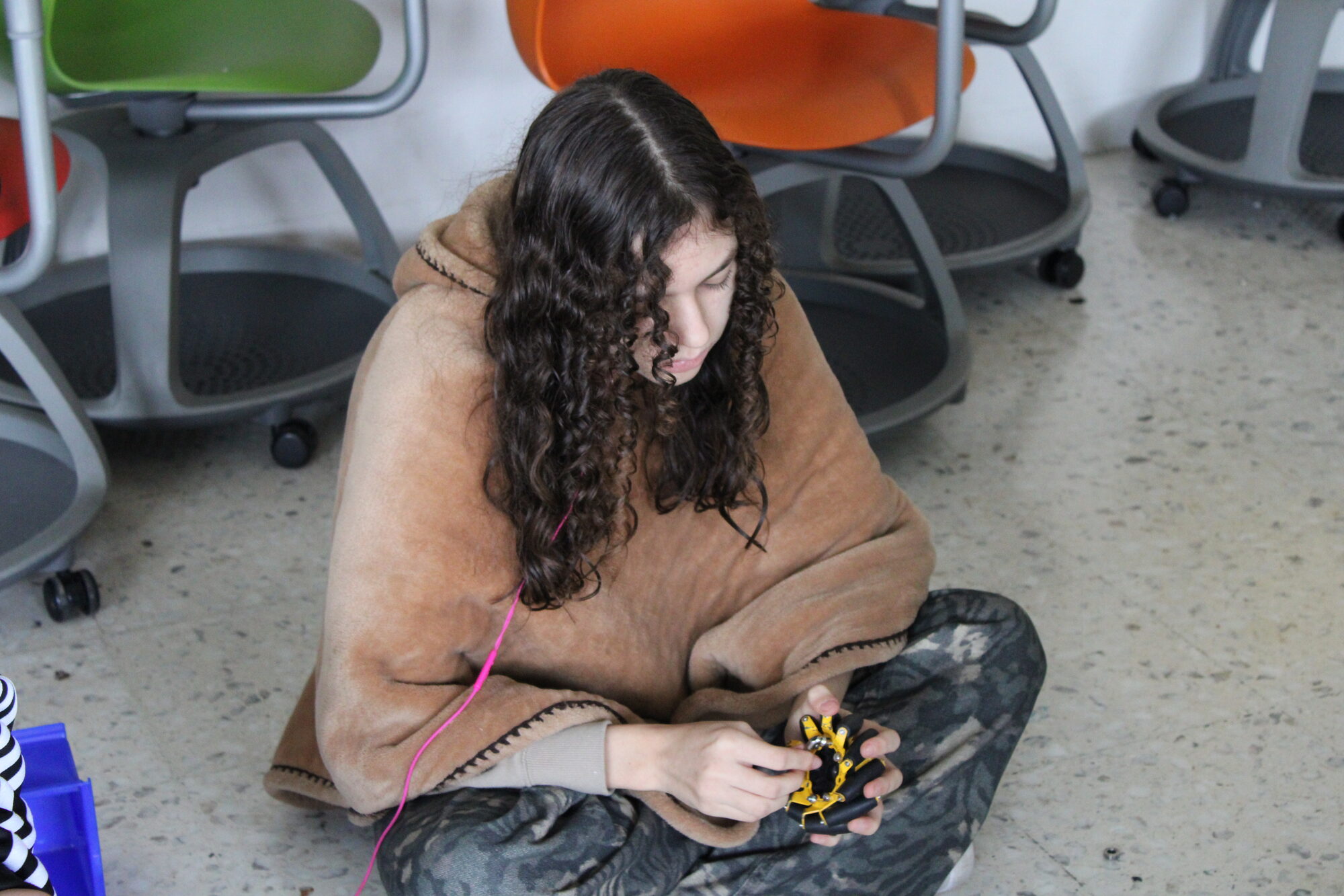 Alumna ensamblando una pieza de un robot FTC